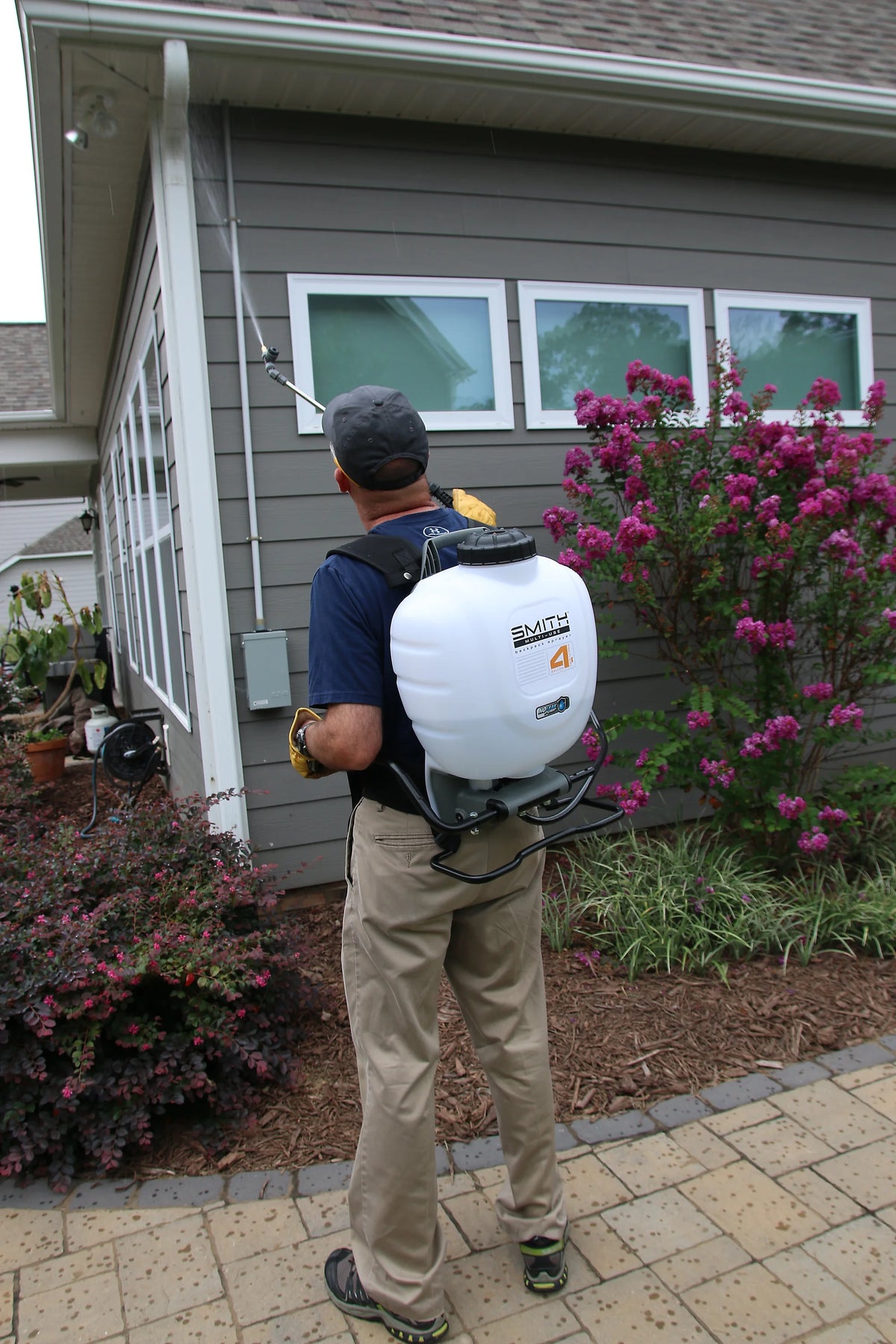 Smith Multi-Use backpack sprayer treating house eaves, Model 190670